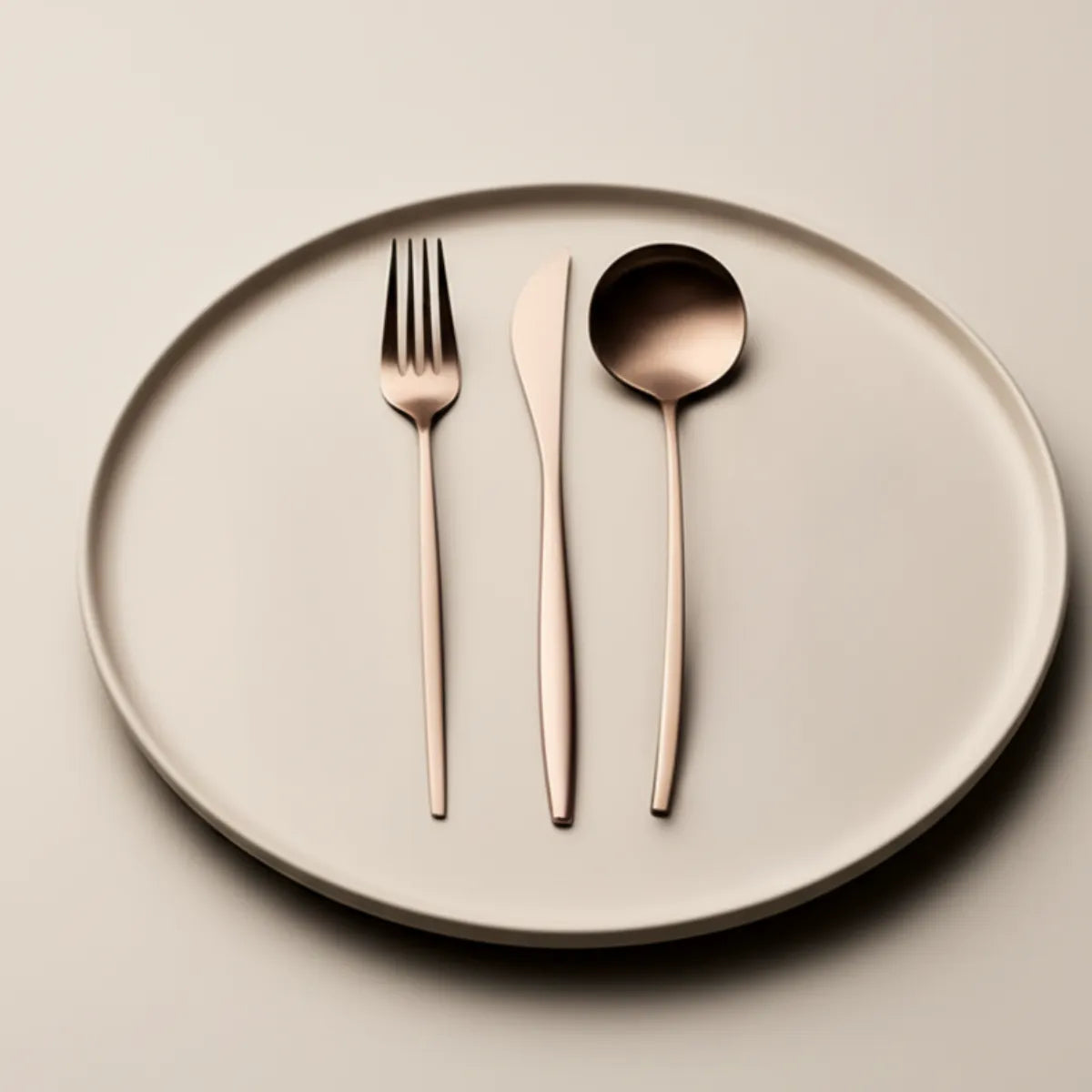 jogo-de-talheres-em-inox-lumiere-rose-24-pecas-modernize-foto-talheres-rose-em-prato-bege-e-fundo-bege