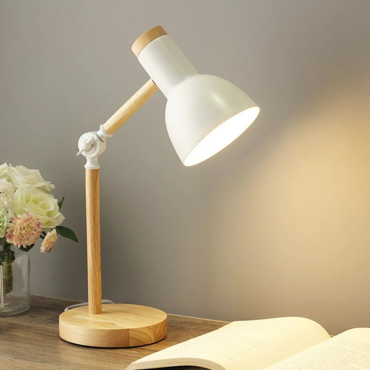 luminaria-abajur-de-mesa-led-articulada-branca-modernize-foto-lateral-luminaria-em-fundo-neutro-ambiente-claro-com-livro-e-flor