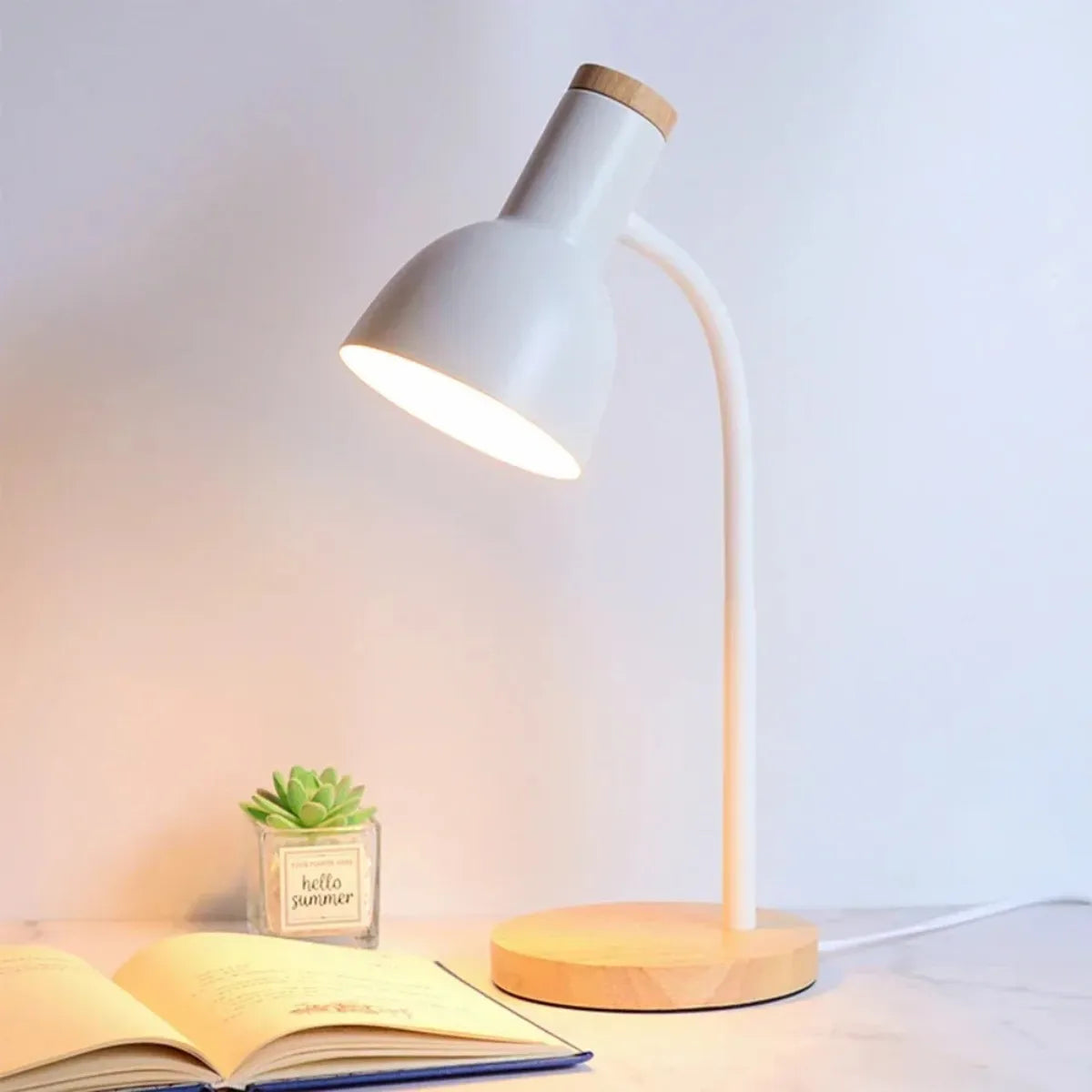 luminaria-abajur-de-mesa-led-curvada-branca-modernize-foto-lateral-luminaria-iluminando-livro-sobre-a-mesa-ambiente-bege-neutro