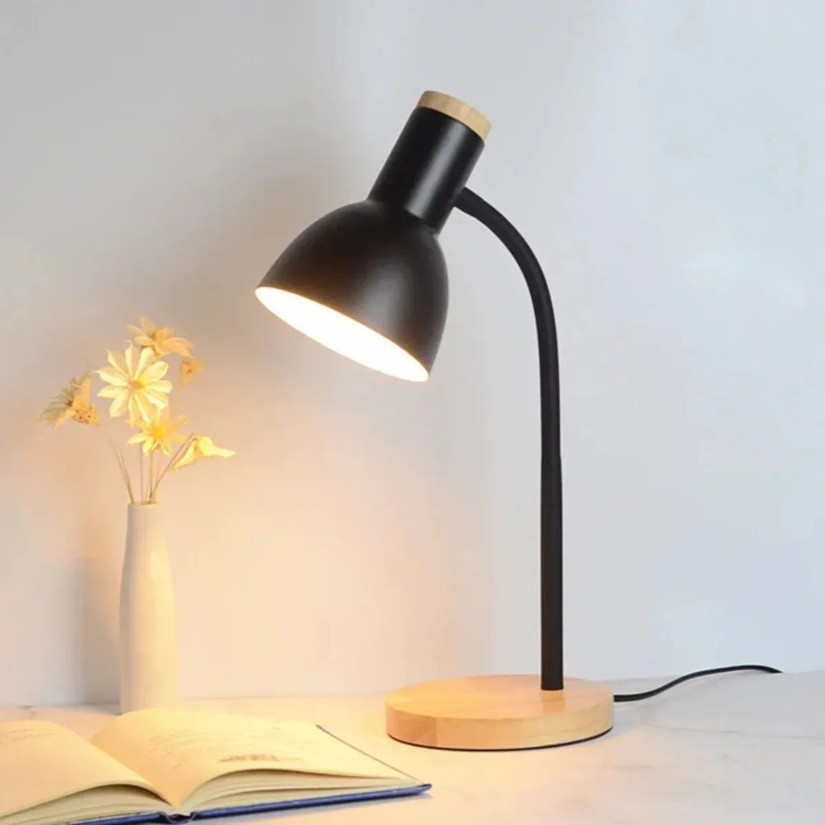 luminaria-abajur-de-mesa-led-curvada-preta-modernize-foto-luminaria-lateral-fundo-neutro-bege-iluminando-livro