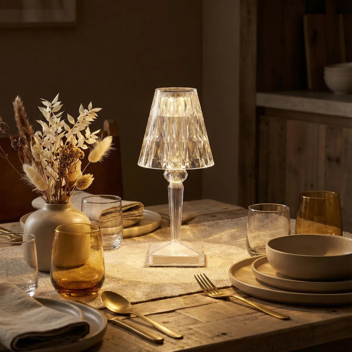Abajur de mesa cristal sem fio usado como centro de mesa em jantar sofisticado, iluminando taças e louças de cerâmica com uma luz intimista e elegante.