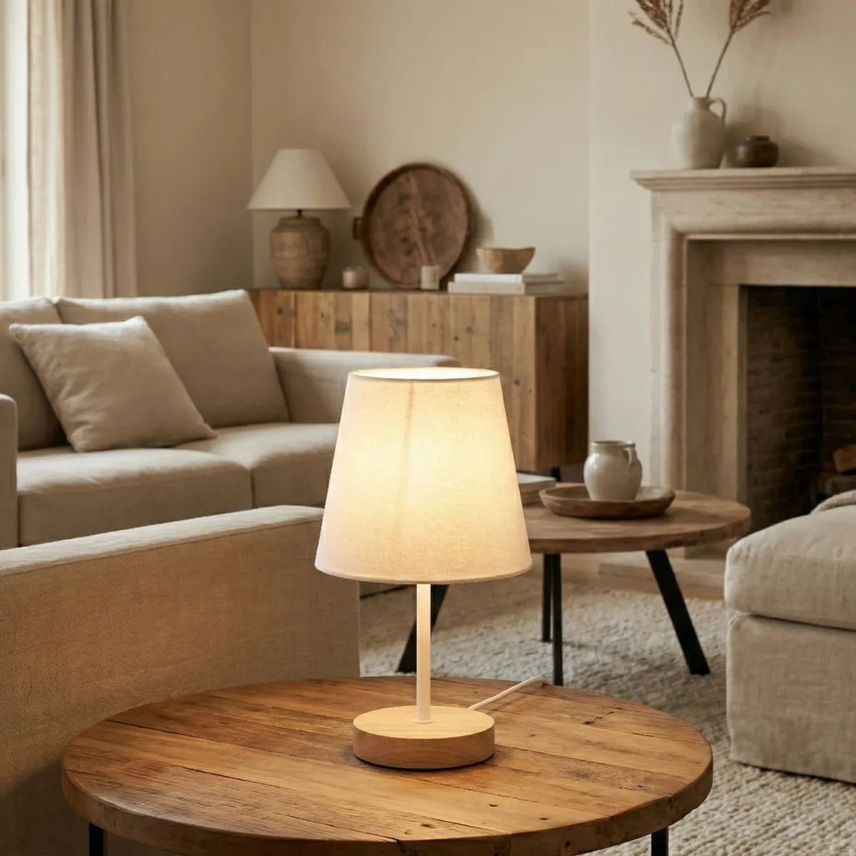 Abajur de mesa retrô decorando mesa de centro redonda de madeira em sala de estar ampla com decoração minimalista e lareira.