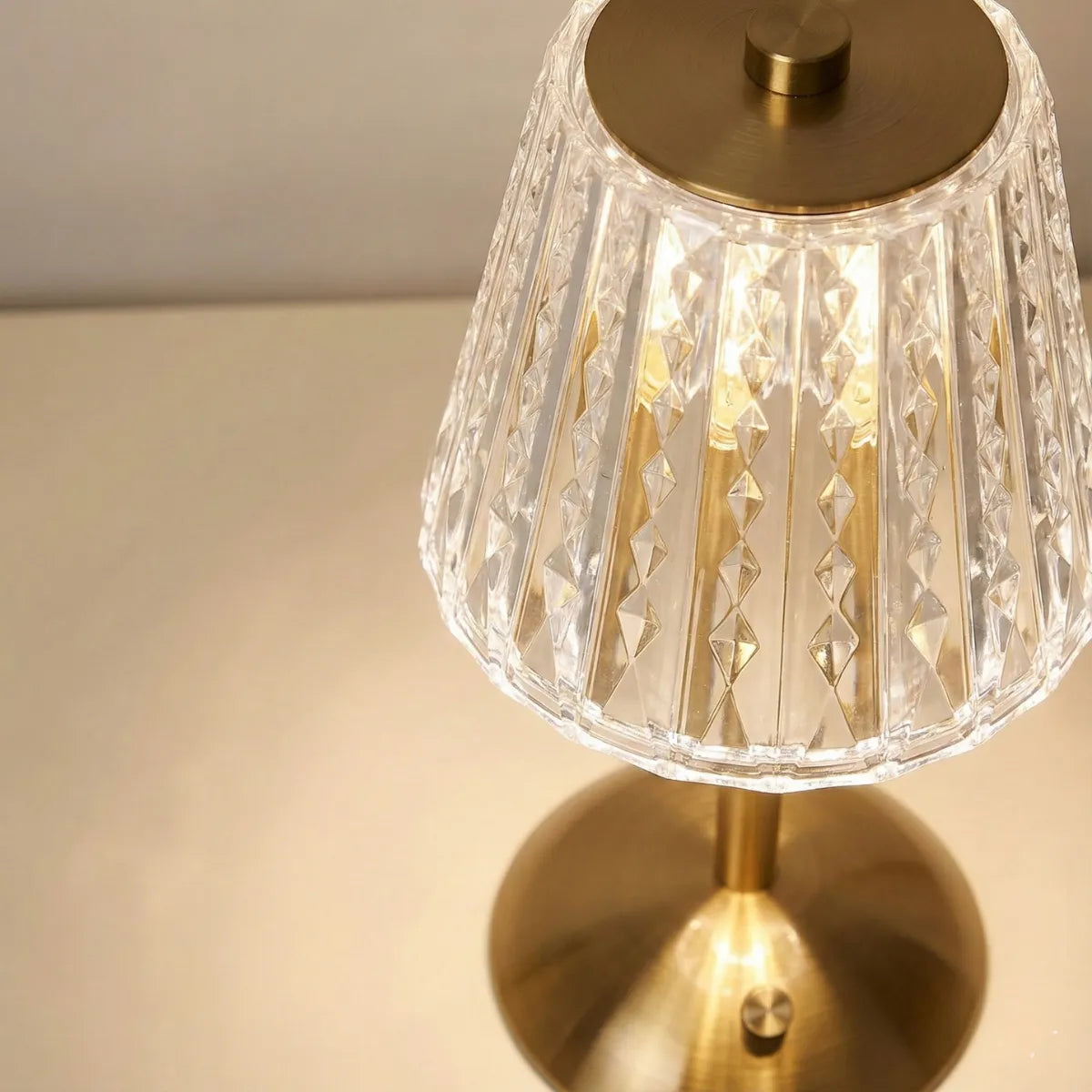 Close-up detalhado (vista superior) mostrando o contraste elegante entre a cúpula transparente texturizada e a estrutura dourada da luminária.