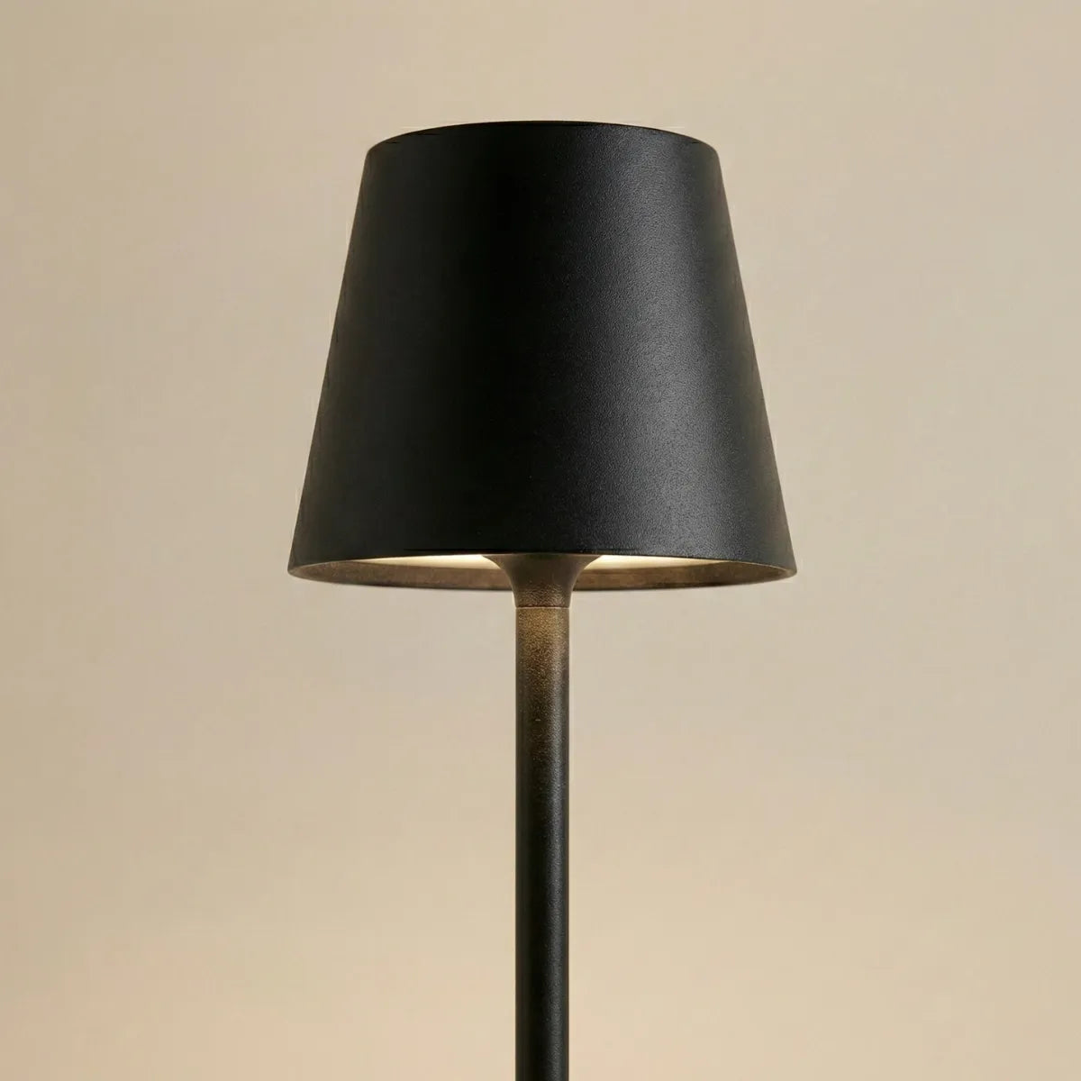 Detalhe do acabamento preto fosco e da haste fina e elegante do abajur de mesa Slim com foco na qualidade do material.