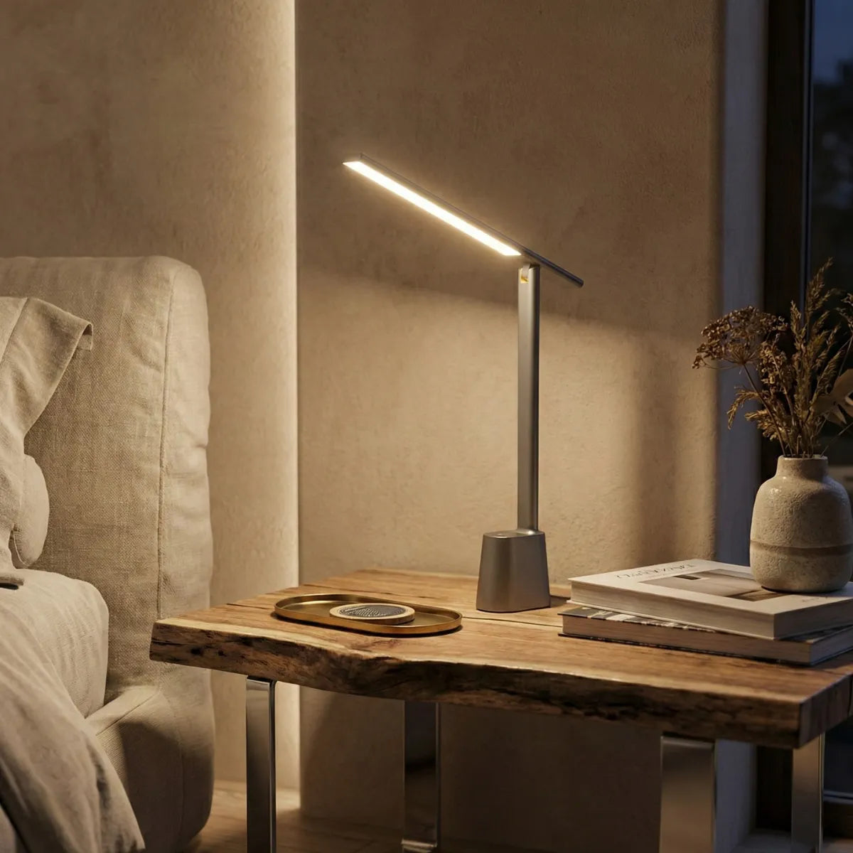 Luminária de mesa Baseus cinza acesa em ambiente escuro sobre mesa de madeira criando iluminação focada e aconchegante à noite.
