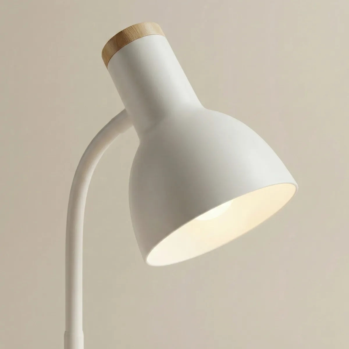 Detalhe da cúpula direcionável da luminária de mesa Locus branca com acabamento fosco e topo de madeira.