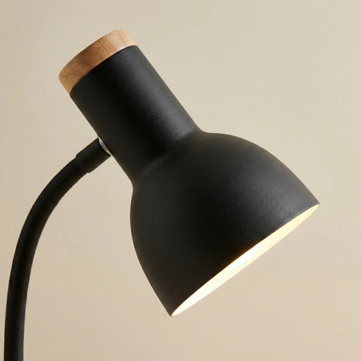 Detalhe da cúpula direcionável preta fosca da luminária Locus com foco no acabamento premium e detalhe em madeira no topo.