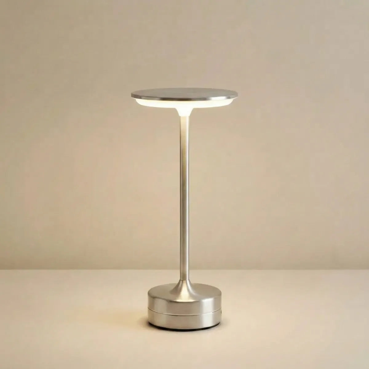 Luminária de mesa minimalista Majestic na cor prata com design moderno sem fio isolada em fundo neutro.