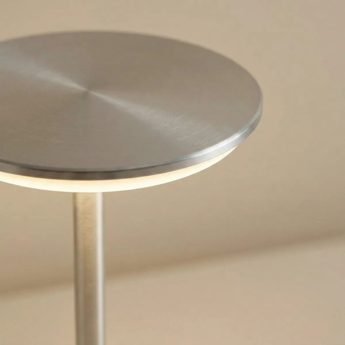 Detalhe do acabamento metálico escovado da luminária de mesa Majestic prata focando no design minimalista da cúpula LED.