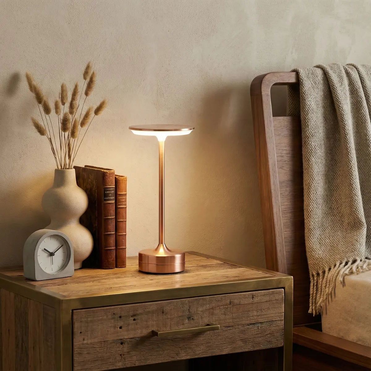 Luminária de cabeceira Majestic Rose Gold sobre mesa de madeira rústica em quarto aconchegante com decoração neutra.