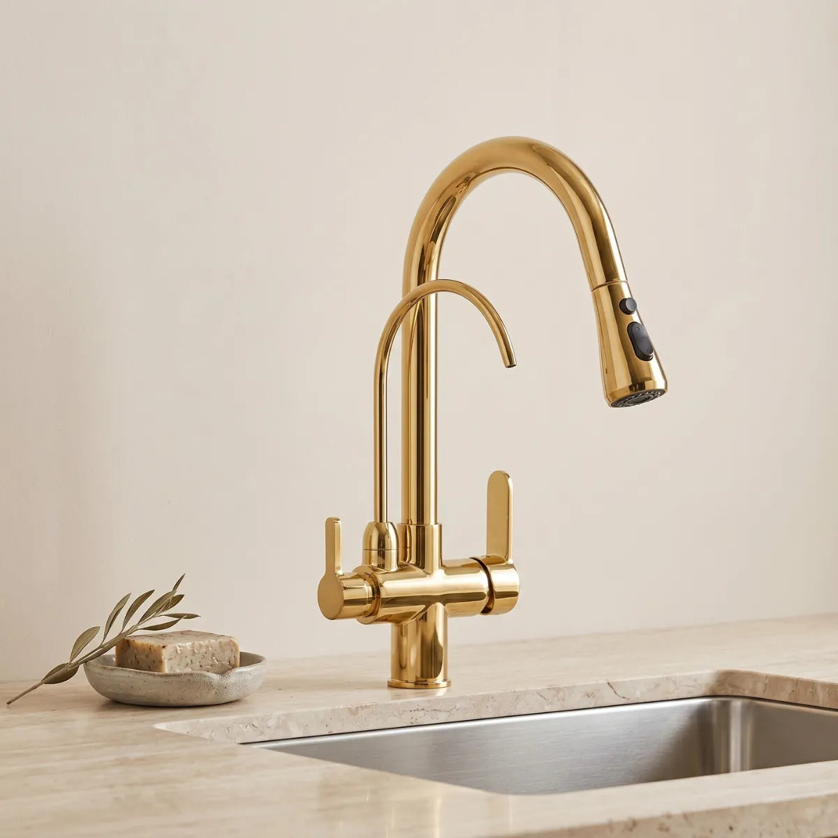 Fotografia completa de uma torneira dpara cozinha gourmet Midas, de aço inoxidável, com design de arco alto. Possui um monocomando, uma mola helicoidal central, uma ducha extensível e um bico separado para água potável. O conjunto está sobre um fundo bege.