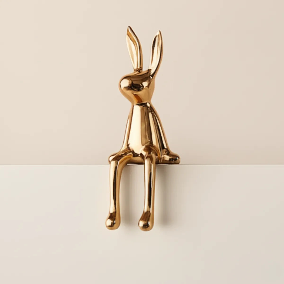 escultura-decorativa-coelho-dourado-modernize-foto-lateral-escultura-de-coelho-em-fundo-bege