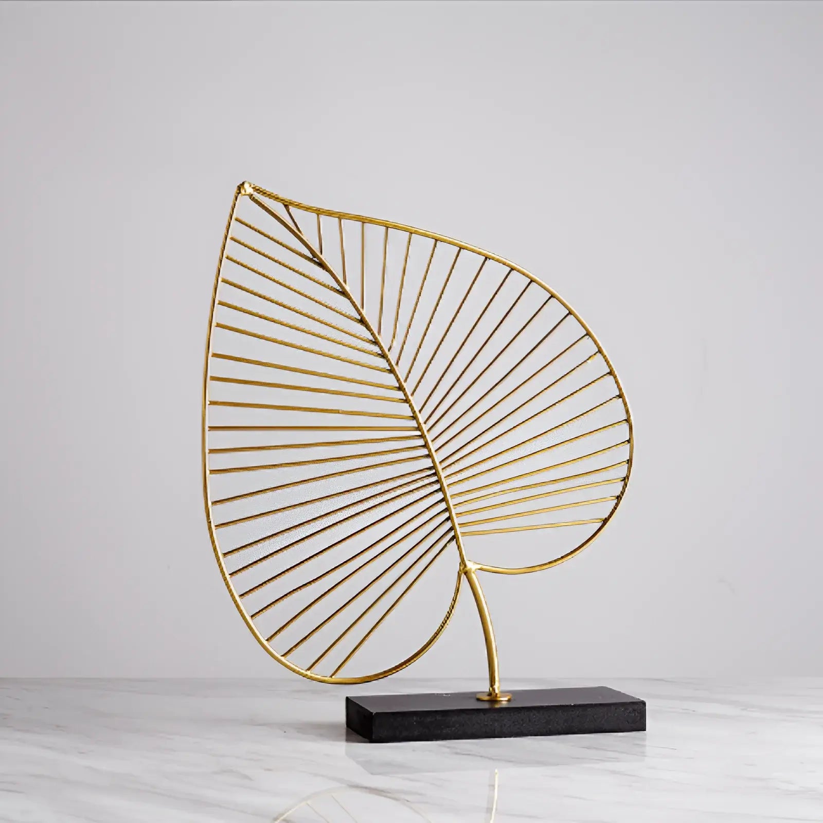 Escultura-decorativa-folha-dourada-em-resina-modernize-foto-escultura-em-mesa-mármore-branca-ambiente-claro