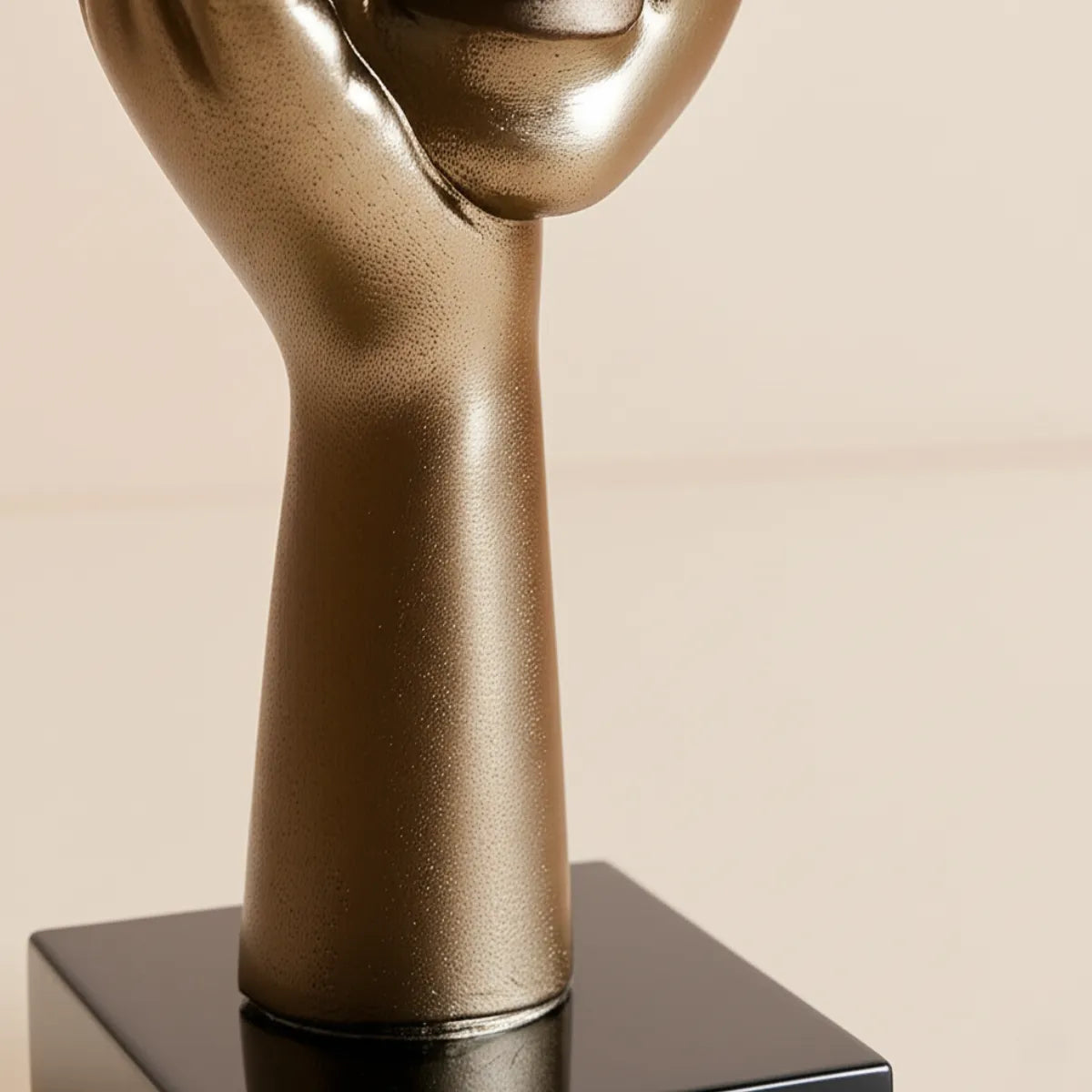 escultura-decorativa-mao-na-face-dourado-modernize-foto-detalhe-base-escultura-fundo-bege-claro