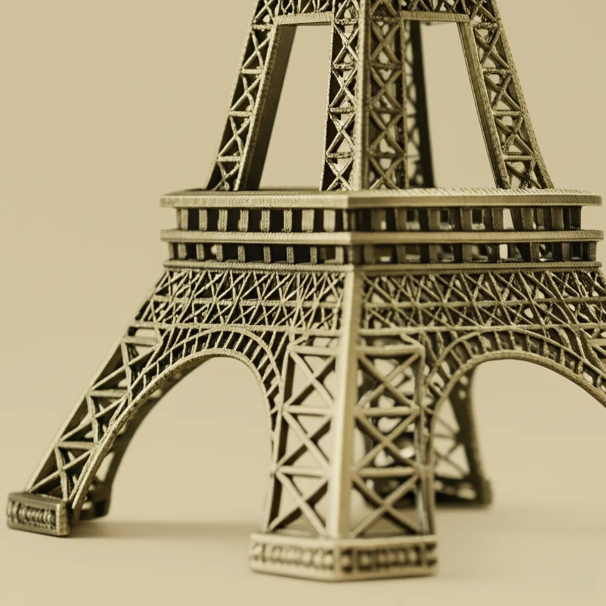 escultura-decorativa-torre-eiffel-paris-modernize-foto-detalhe-base-torre-em-ambiente-claro-fundo-bege