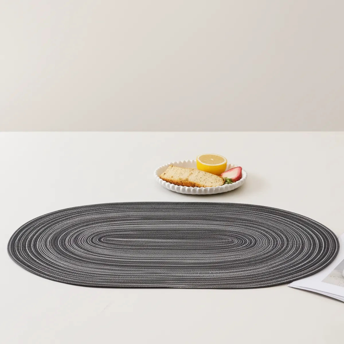 jogo-americano-oval-poliester-cinza-4-lugares-modernize-foto-jogo-americano-cinza-em-fundo-bege-com-prato-de-delicias