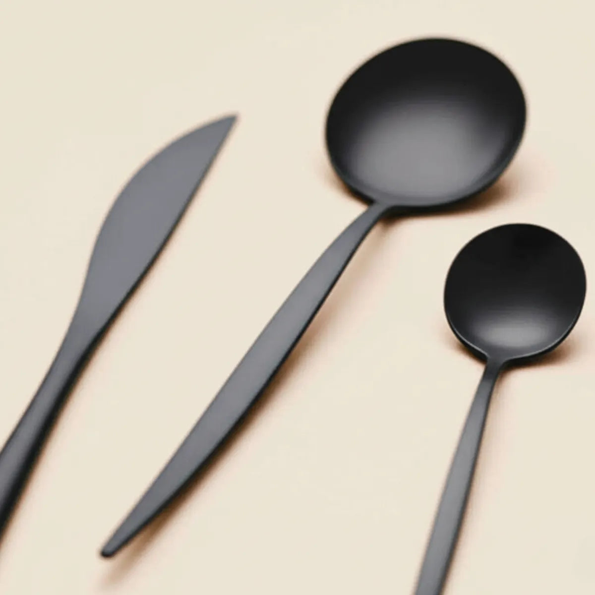 jogo-de-talheres-em-inox-elegance-preto-30-pecas-modernize-foto-detalhe-talheres-em-ambiente-claro-fundo-bege