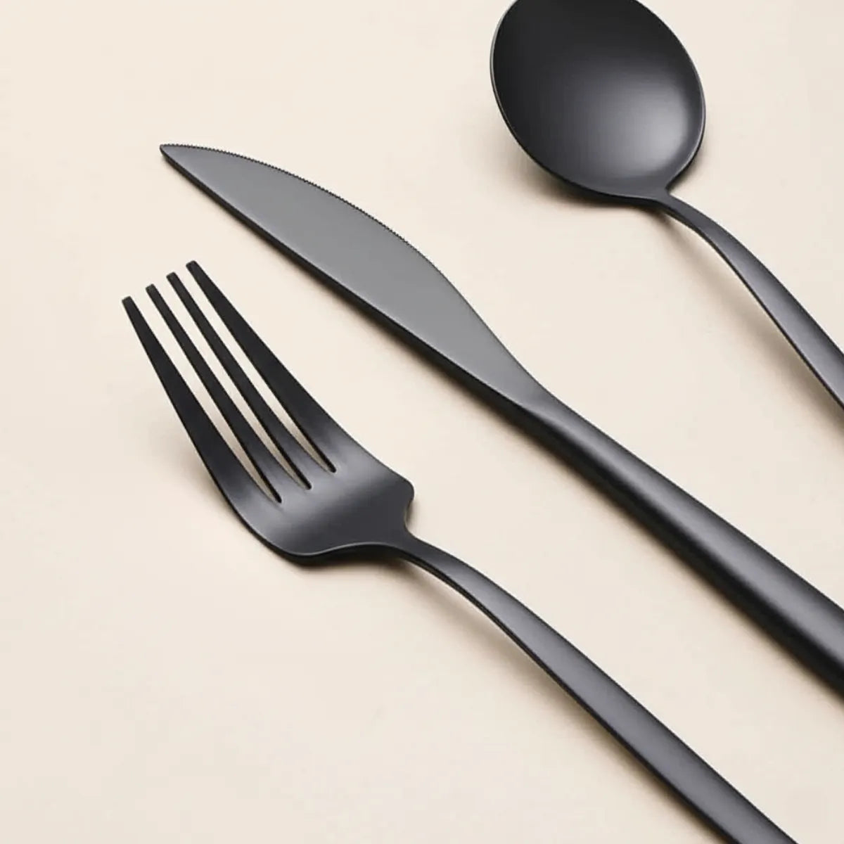 jogo-de-talheres-em-inox-elegance-preto-30-pecas-modernize-foto-detalhe-garfo-e-faca-em-ambiente-claro-fundo-bege