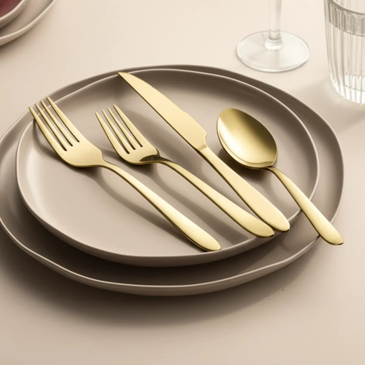 jogo-de-talheres-em-inox-golden-dourado-24-pecas-modernize-foto-talheres-dourados-em-prato-cinza