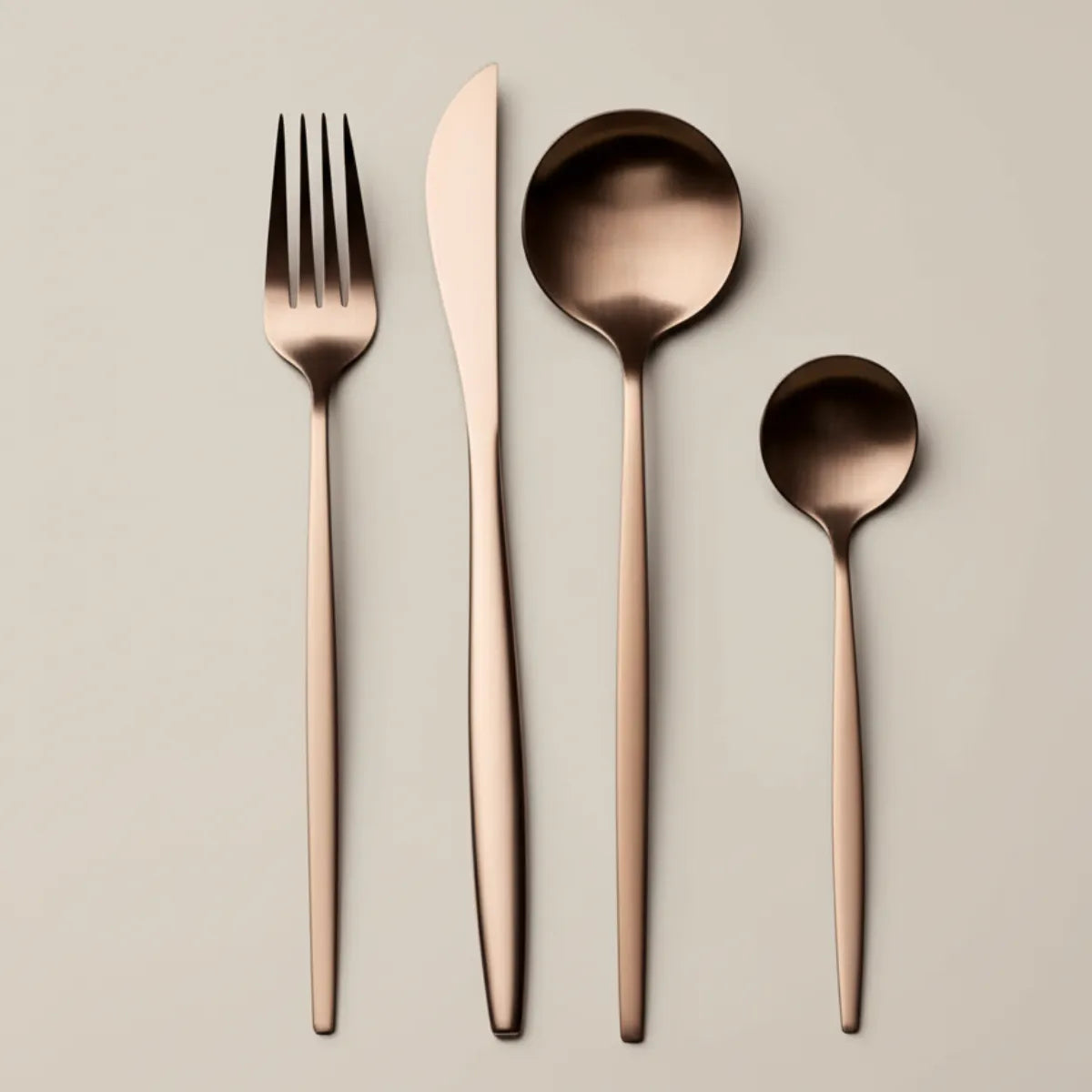 jogo-de-talheres-em-inox-lumiere-rose-24-pecas-modernize-foto-talheres-rose-em-fundo-bege