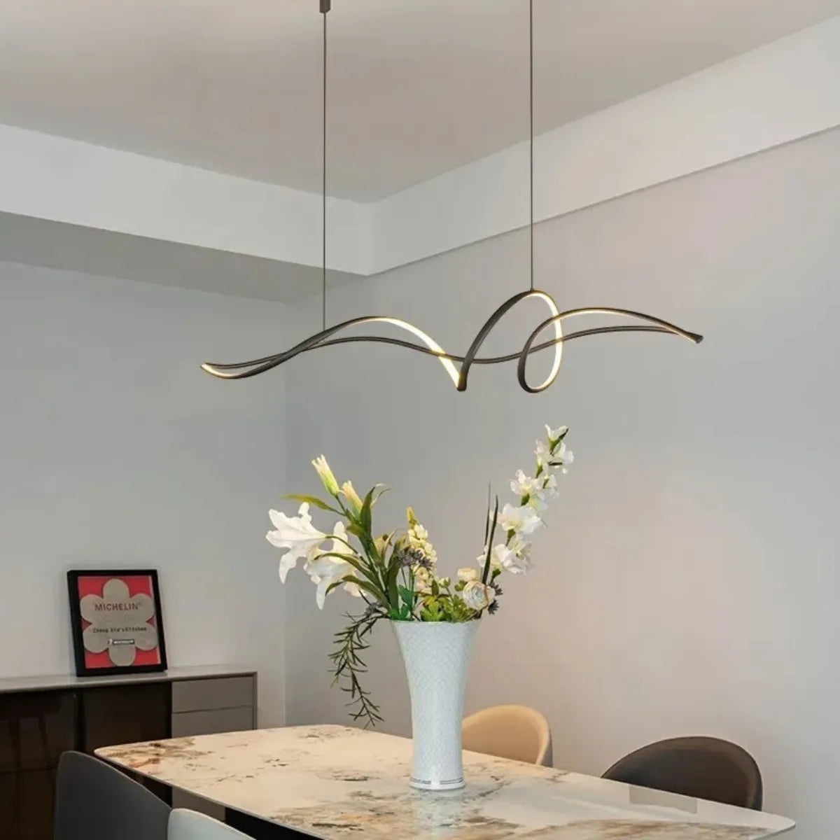 luminaria-de-teto-lustre-pendente-led-curvilineo-modernize-foto-lateral-lustre-iluminando-ambiente-neutro-bege