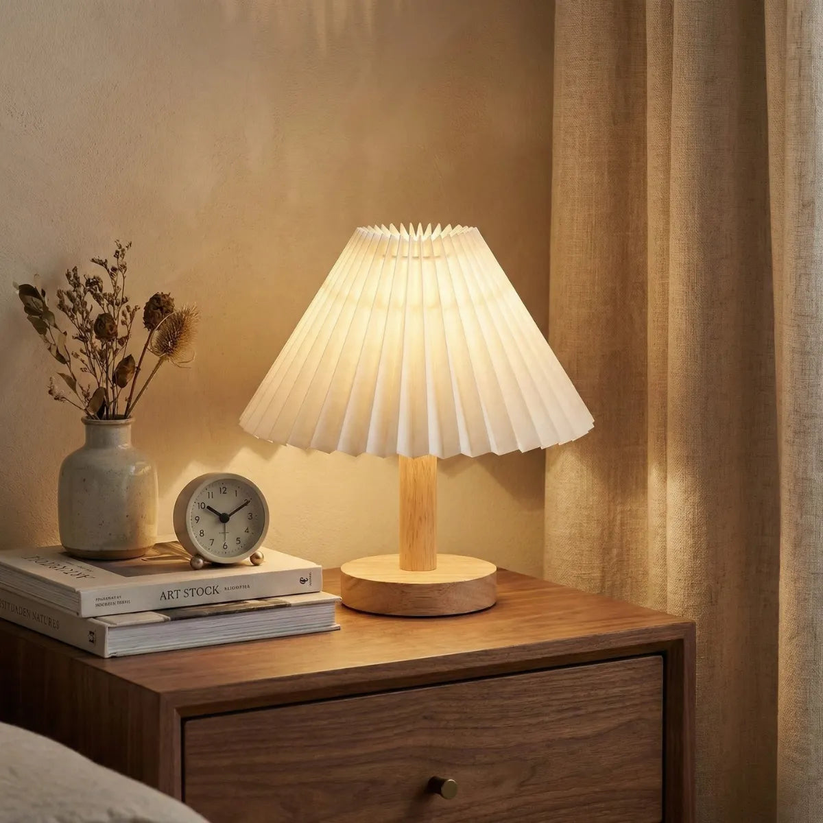 Abajur de cabeceira estilo Japandi com cúpula plissada iluminando mesa de apoio de madeira em quarto aconchegante.