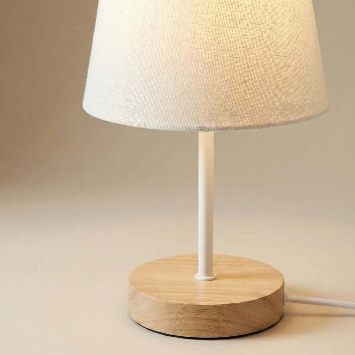 Detalhe da textura da cúpula de tecido e acabamento da base de madeira natural do abajur de mesa retrô.