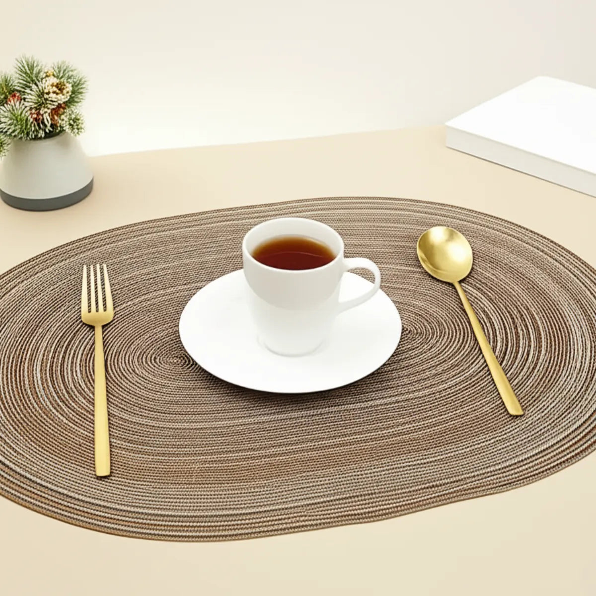 jogo-americano-oval-poliester-marrom-4-lugares-modernize-foto-jogo-americano-marrom-poliester-com-xicara-e-talheres-em-fundo-bege