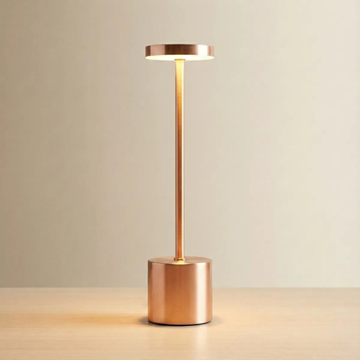Luminária de mesa Allure com acabamento Rose Gold (cobre), design minimalista com base cilíndrica e topo plano, fundo neutro.