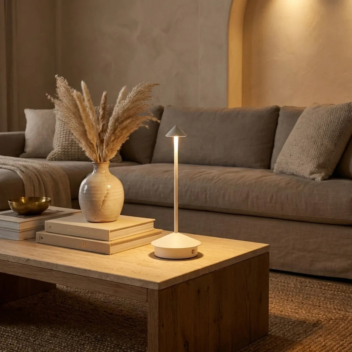 Luminária de mesa sem fio Apollo branca compondo decoração de sala de estar elegante em mesa de centro de mármore com tons neutros.