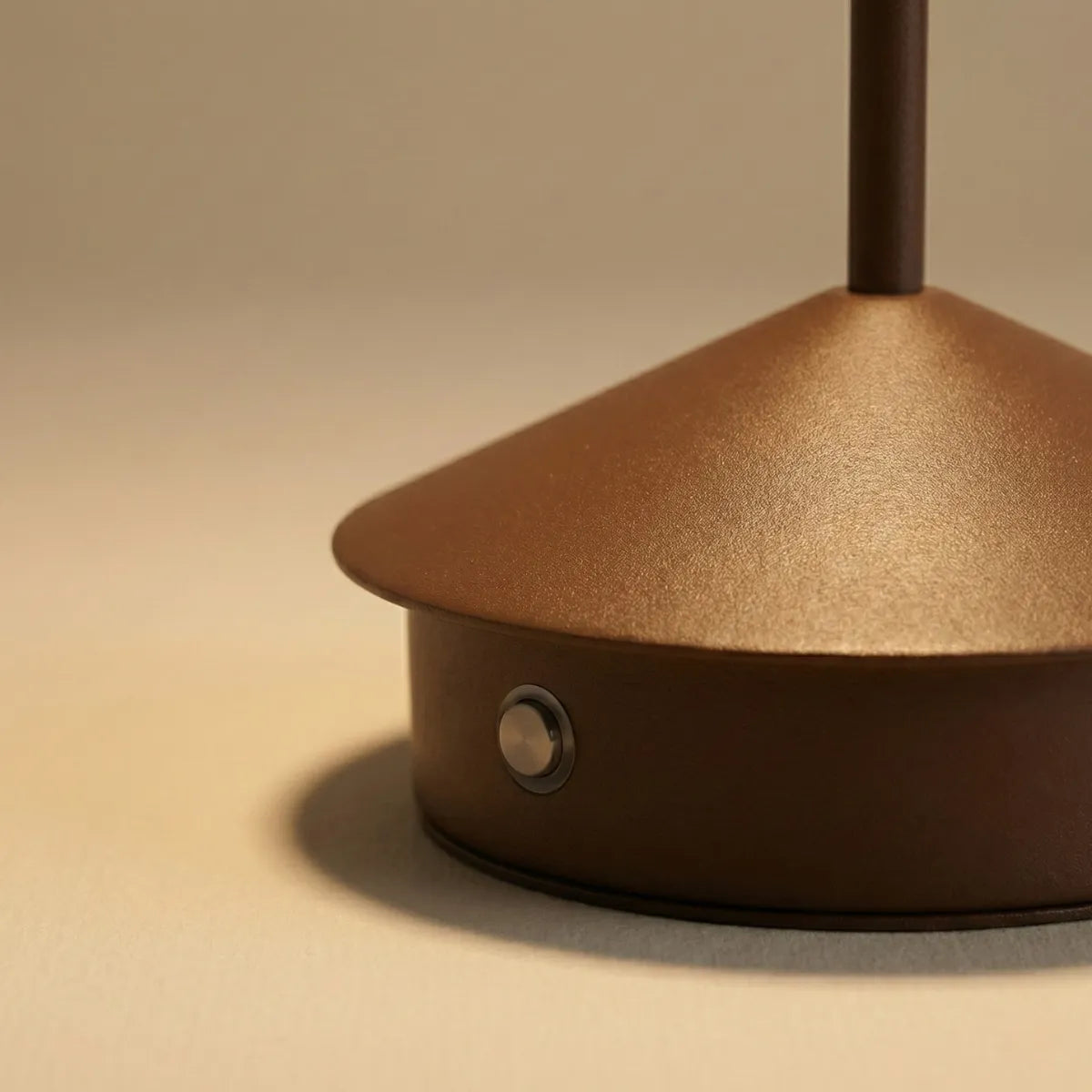Detalhe da base e acabamento da luminária de mesa Apollo marrom com foco na textura premium e botão de toque.