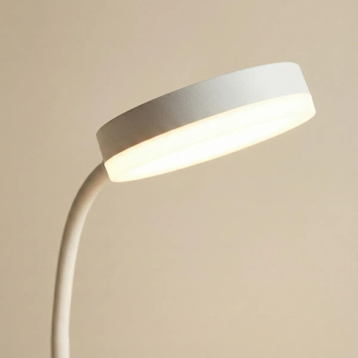 Close-up detalhado da cúpula redonda da luminária LED, destacando o acabamento branco fosco de alta qualidade e a difusão suave da luz.