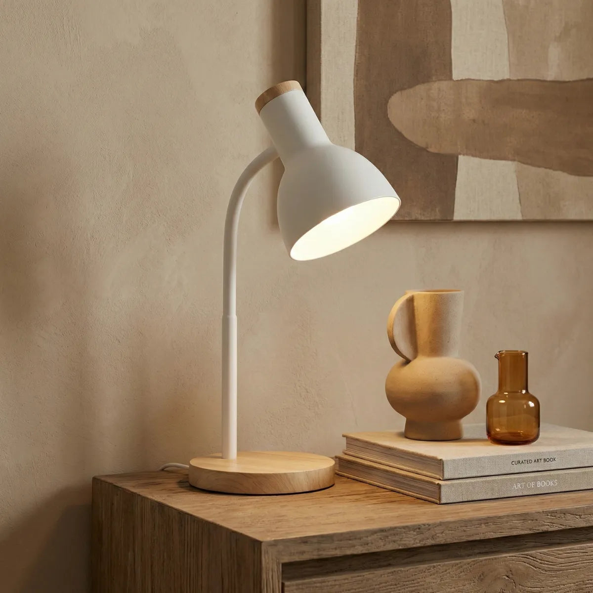 Luminária decorativa Locus branca sobre aparador de madeira com vasos de cerâmica e quadro abstrato ao fundo.