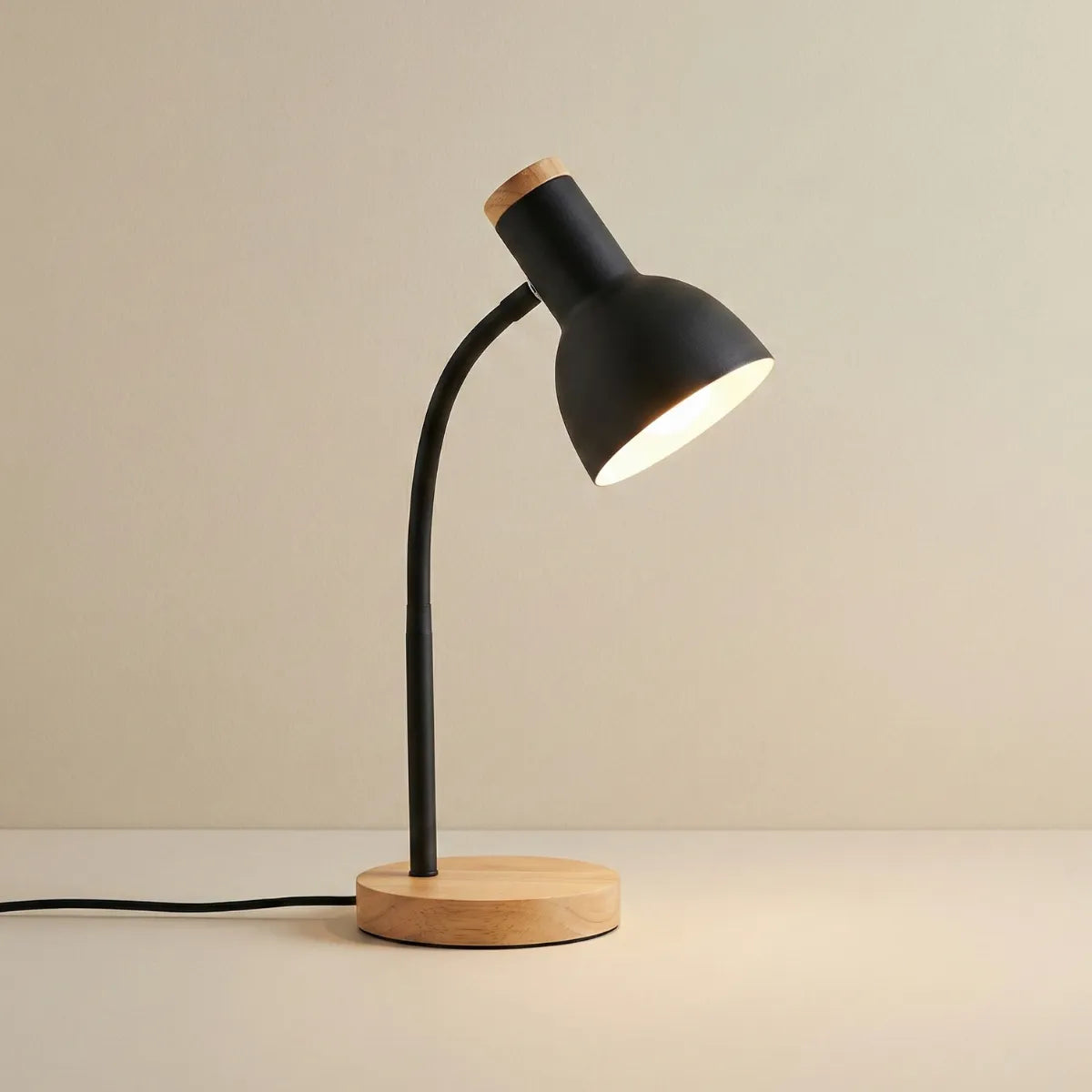 Luminária de mesa articulada Locus preta com base de madeira e design escandinavo moderno isolada em fundo neutro.