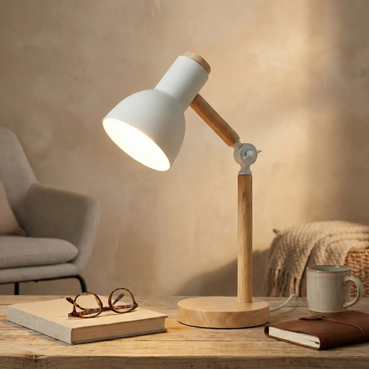Luminária de mesa para leitura Pinus branca iluminando escrivaninha rústica com óculos e livro em home office aconchegante.