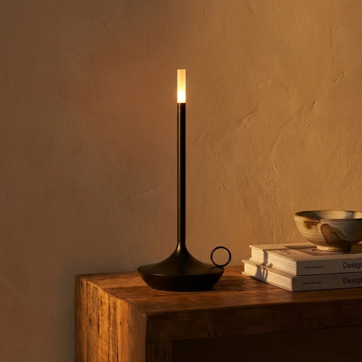 Luminária sem fio Venia preta em mesa lateral, criando iluminação de ambiente suave e acolhedora.