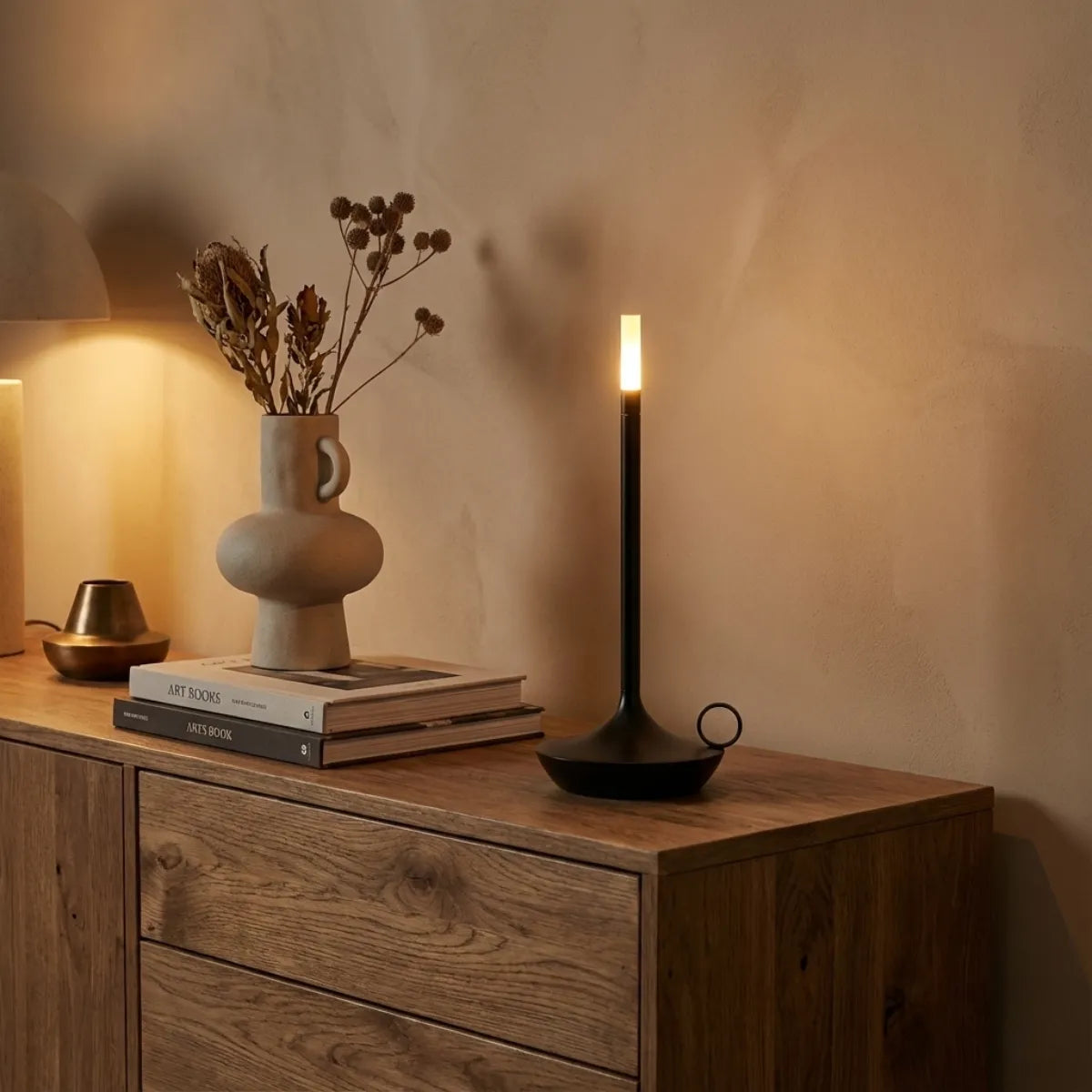 Luminária de mesa moderna Venia compondo decoração sobre aparador de madeira com vasos de cerâmica e flores secas.