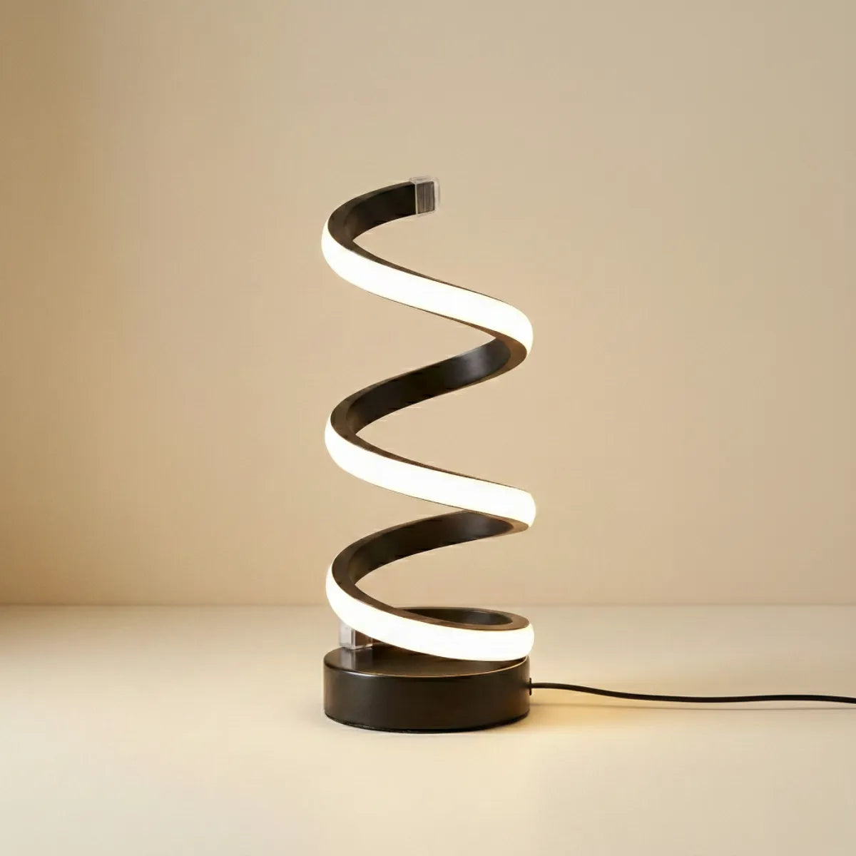 Luminária de mesa Voluta Preta com design espiral moderno e acabamento preto isolada em fundo neutro bege claro.