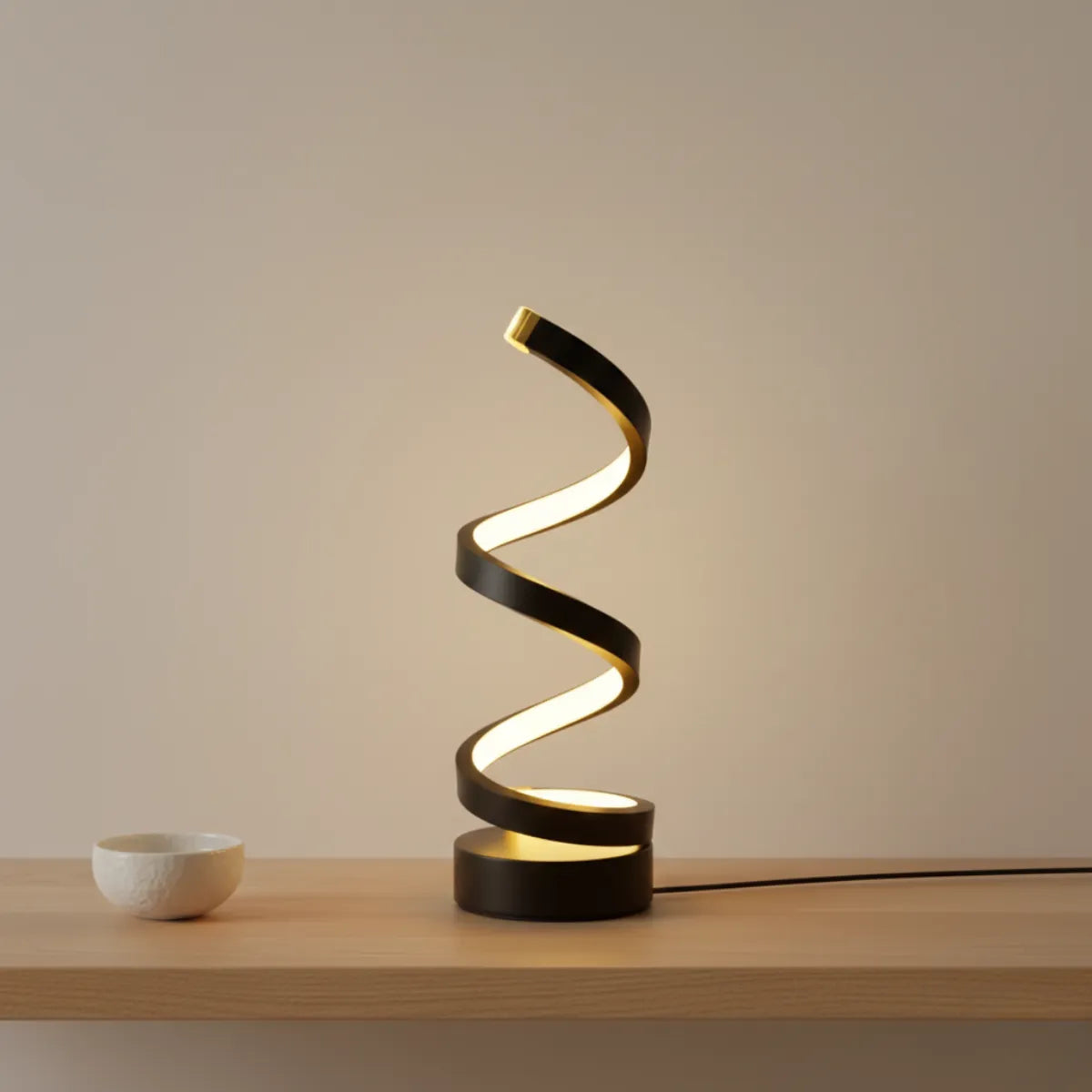 Luminária de mesa minimalista Zenite acesa sobre superfície de madeira clara ao lado de tigela de cerâmica branca, estilo Zara Home.