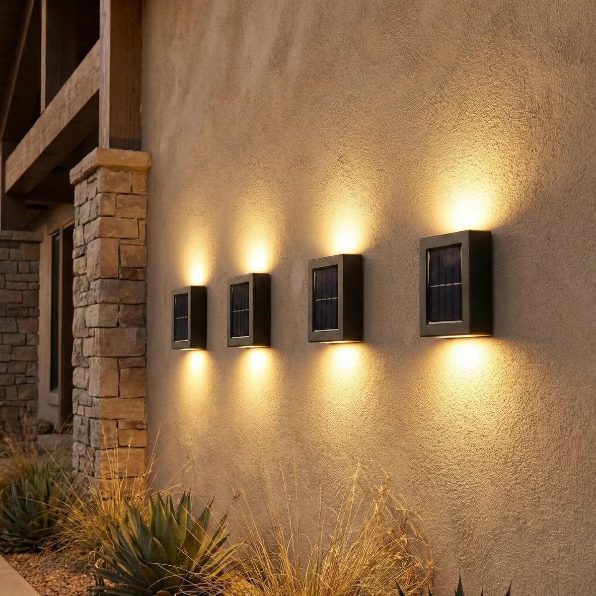 Conjunto de arandelas solares instaladas em sequência em muro externo texturizado, criando iluminação cênica e sofisticada.