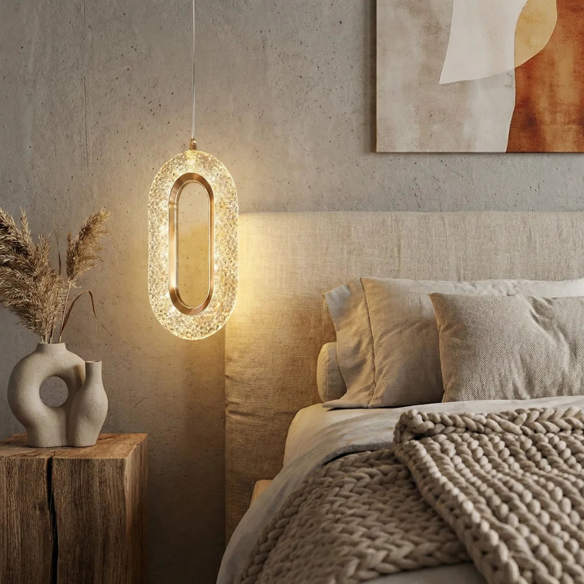 Luminária pendente de cristal dourada iluminando mesa de cabeceira rústica em quarto de casal elegante com tons neutros.