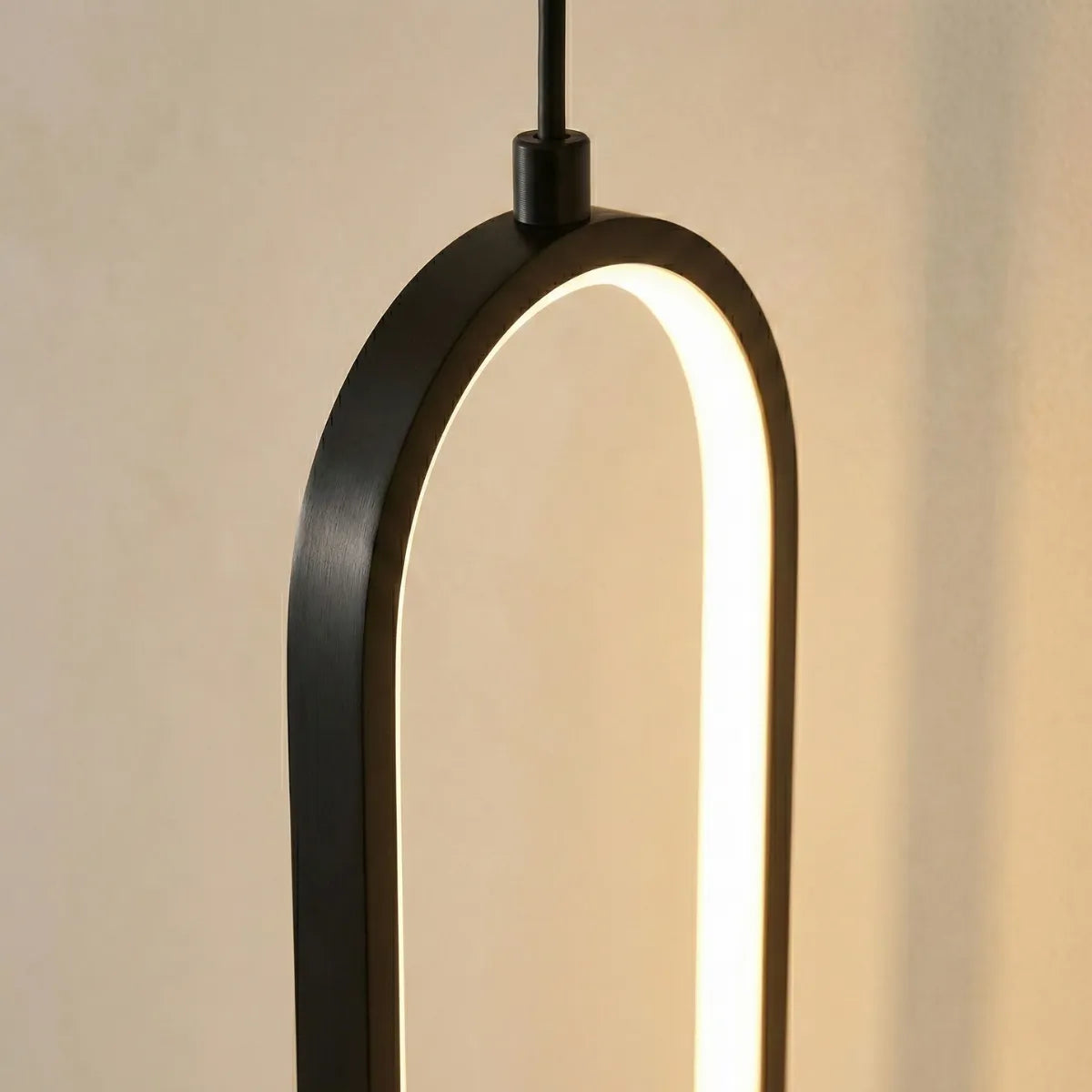 Detalhe do acabamento em metal preto fosco e da fita de LED interna da luminária pendente Elo moderna.