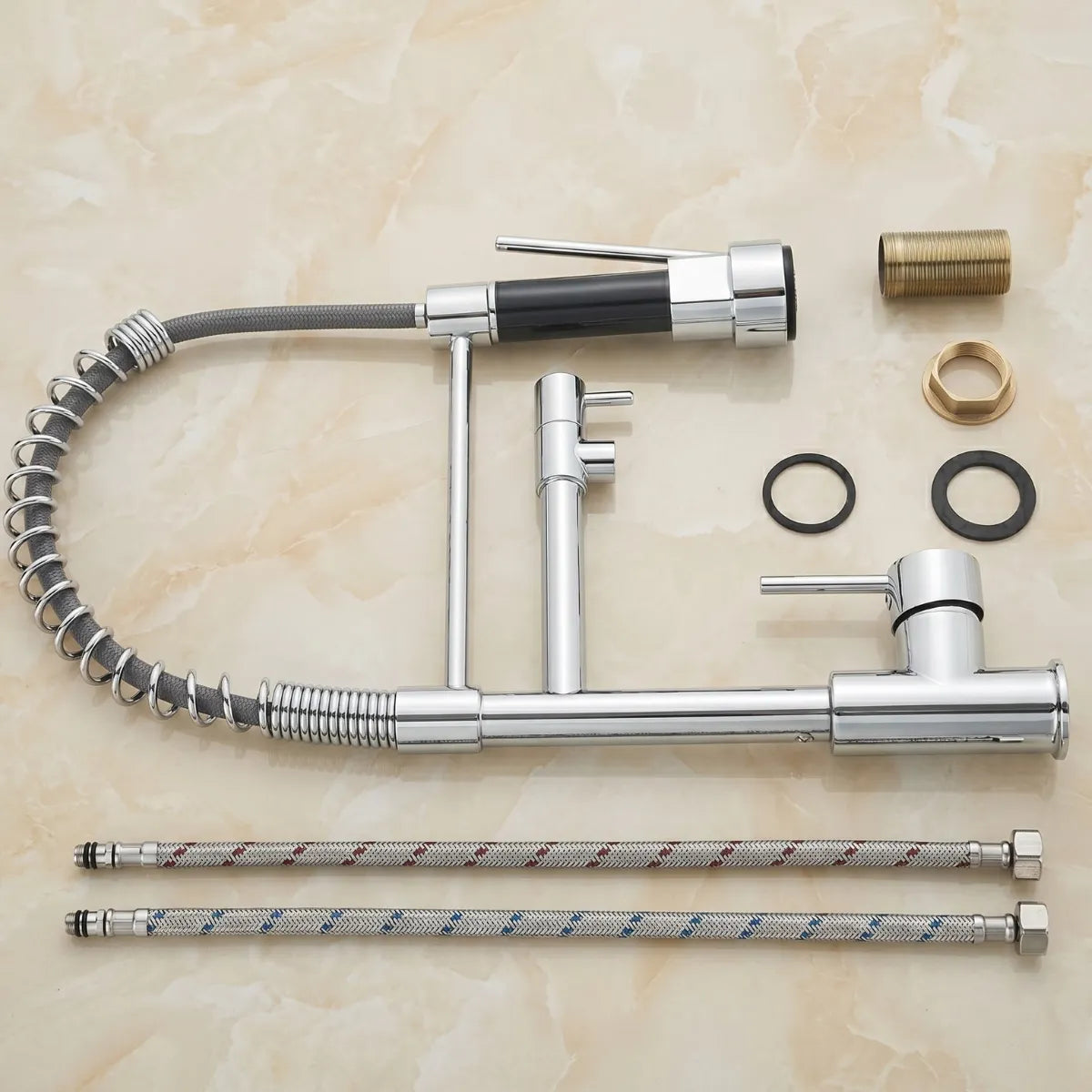 Kit completo da torneira para cozinha flexível cromada desmontada, com corpo, mola espiral, ducha bicolor, bica articulada, mangueiras trançadas, parafusos de latão e vedações sobre mármore.