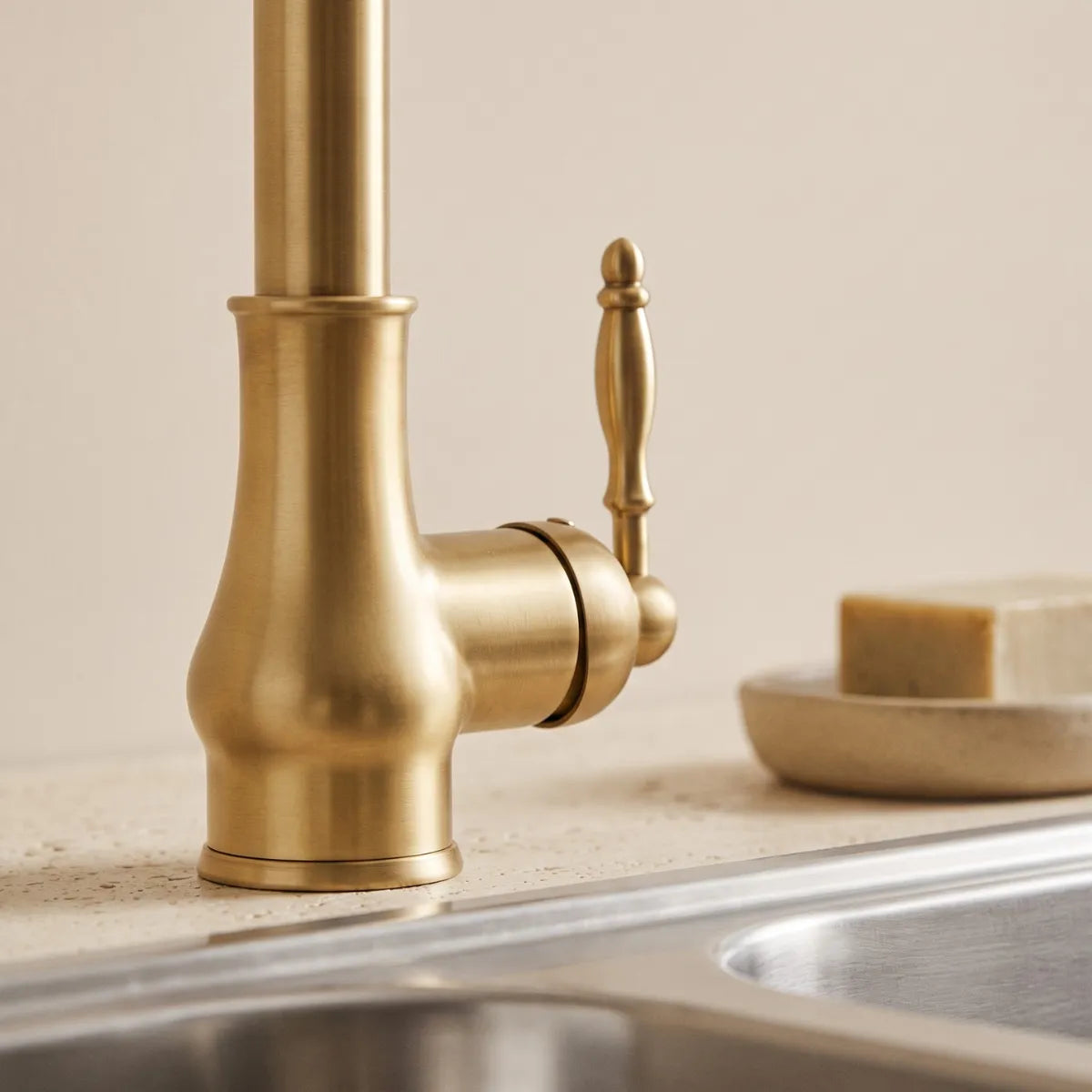Detalhe da base e alavanca ornamentada de torneira gourmet vintage dourada escovada com acabamento premium